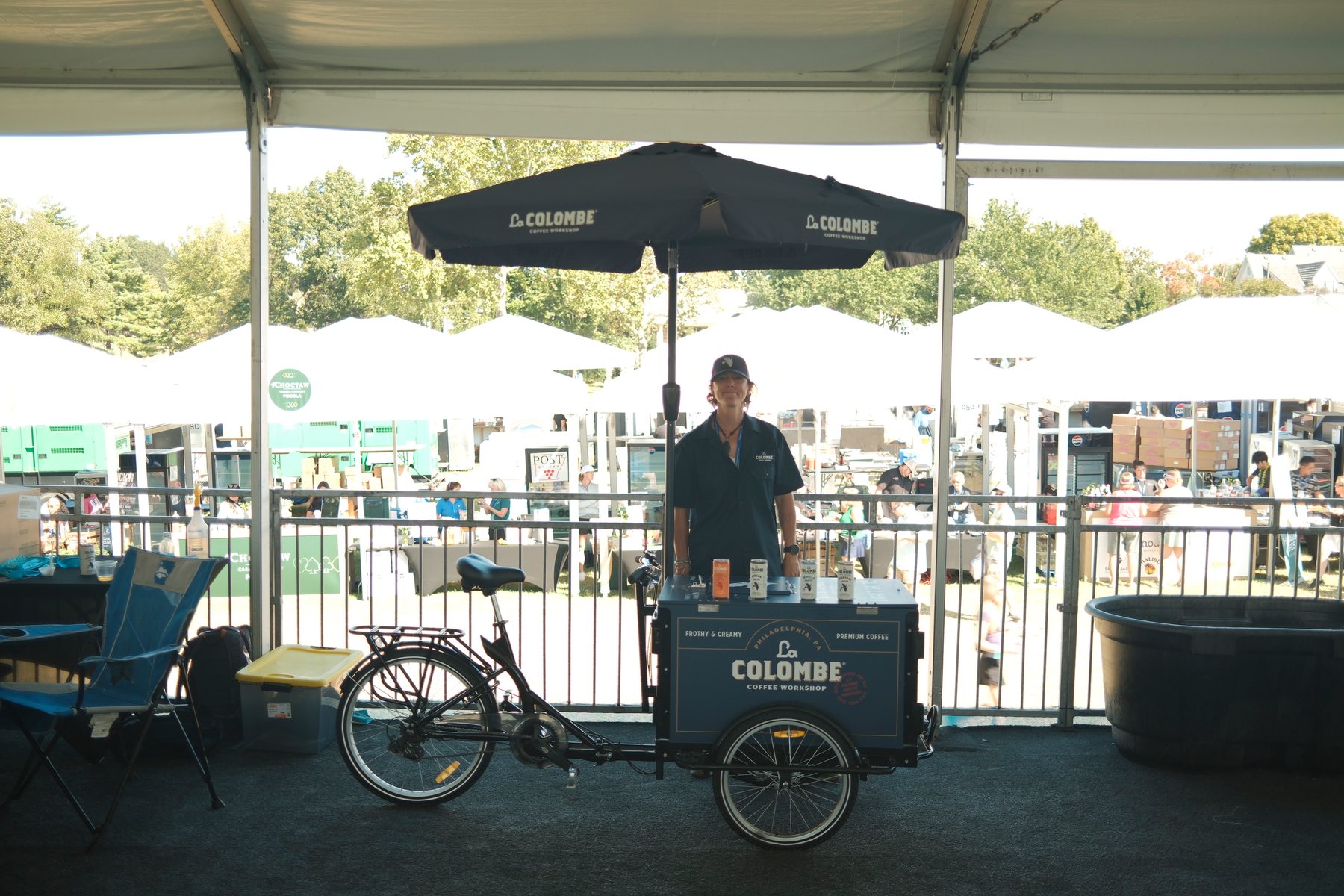 La Colombe brand ambassador behind the coffee trike under a La Colombe umbrella.